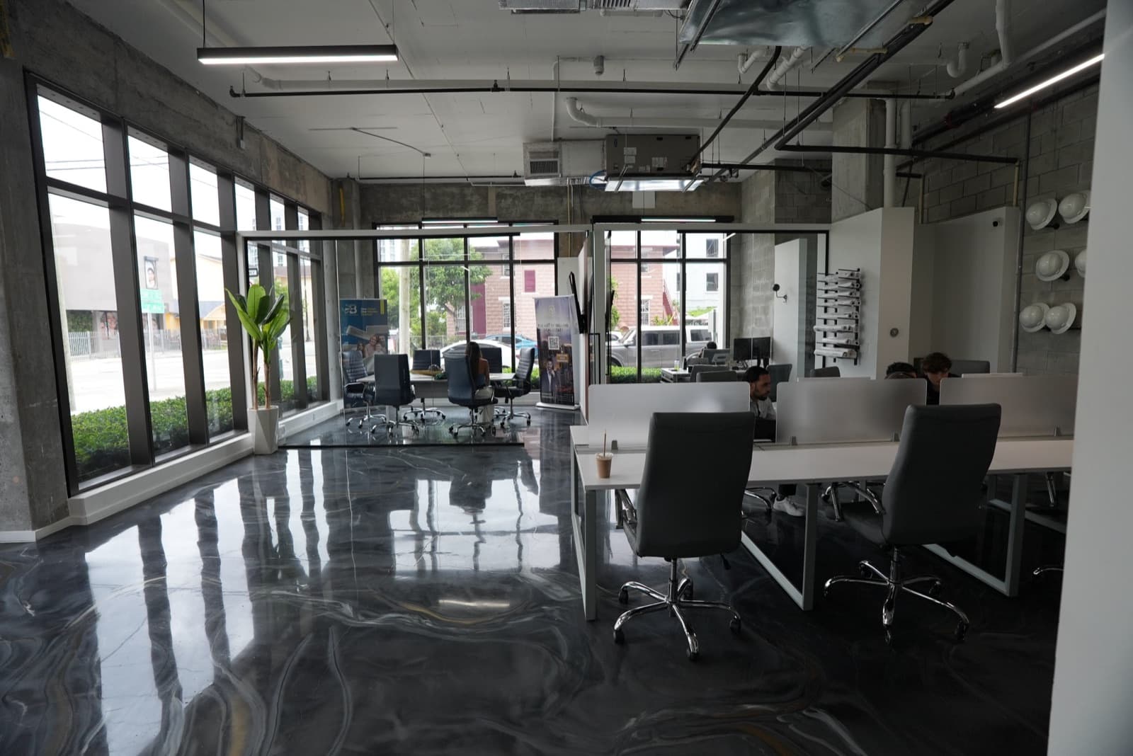 Open sales floor with street-front windows at the Brickell office