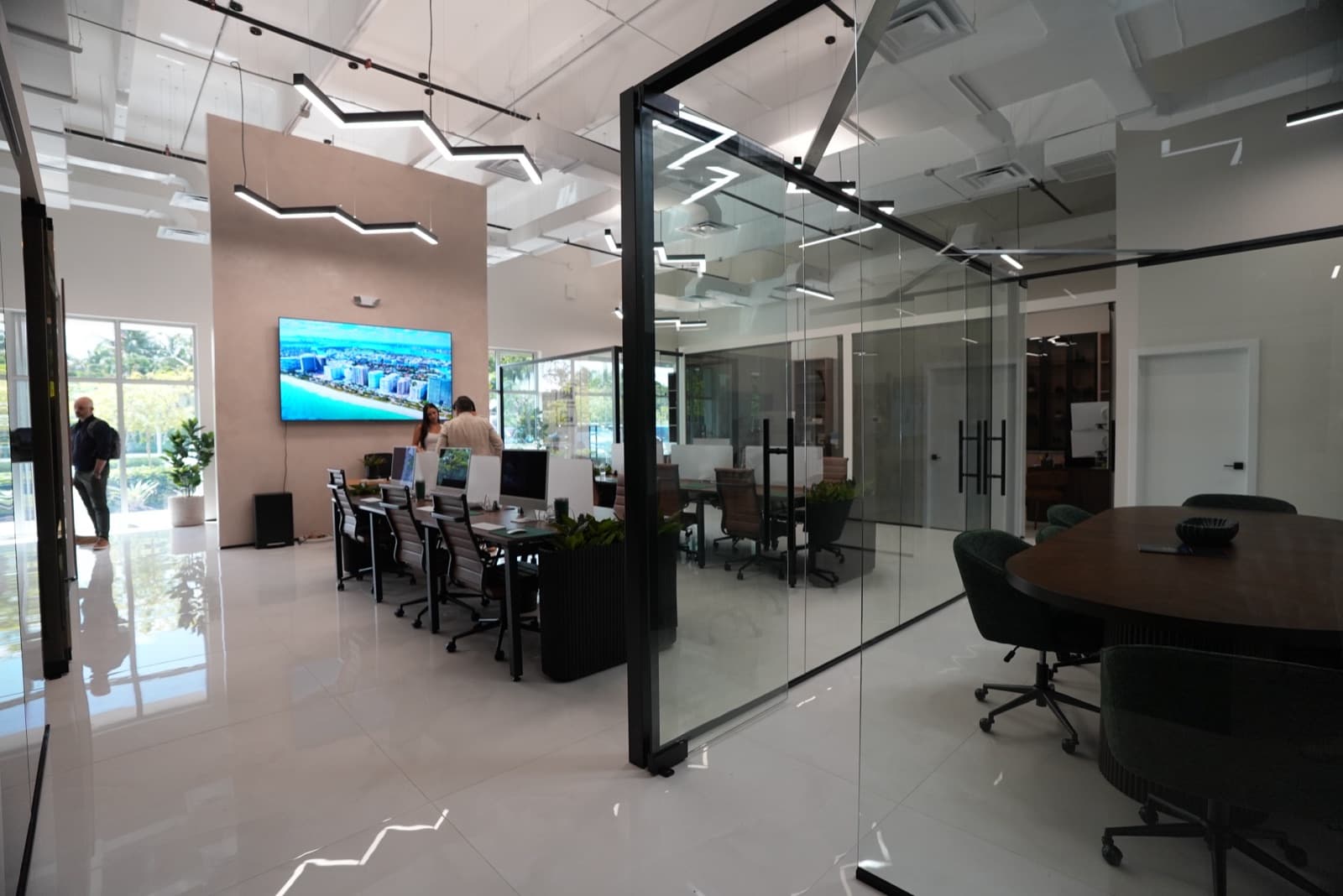 Open floor and glass-walled meeting room at the Doral office